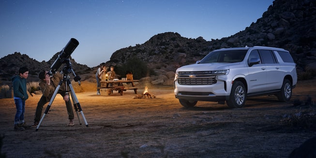 A Couple Camps Out Next to Their Iridescent Pearl Tricoat Suburban