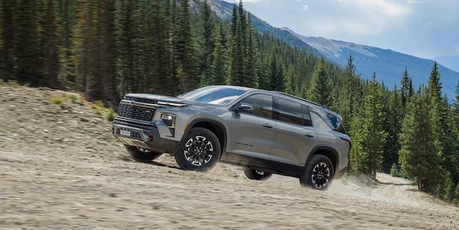 2024 Chevy Traverse Driving Uphill with Mountains in the Background