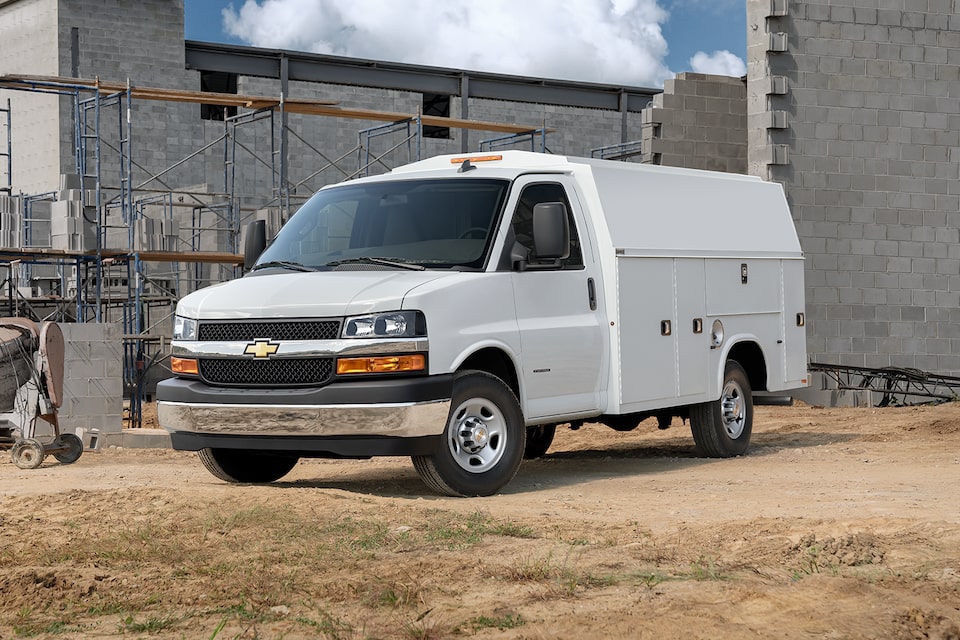 Two 2024 Chevy Commercial Express Vans Parked in a Parking Lot