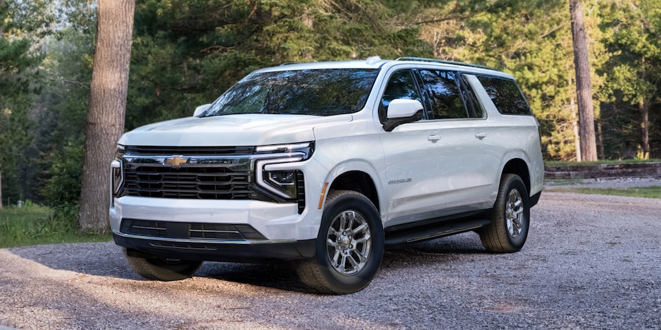 Wide Front Three-Quarters View of the 2025 Chevrolet Suburban SUV Driving on a Road