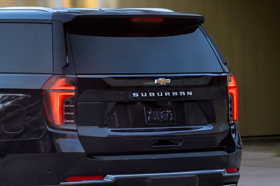 Rear Three-Quarters View of the 2025 Chevrolet Suburban SUV Parked Near a Lake