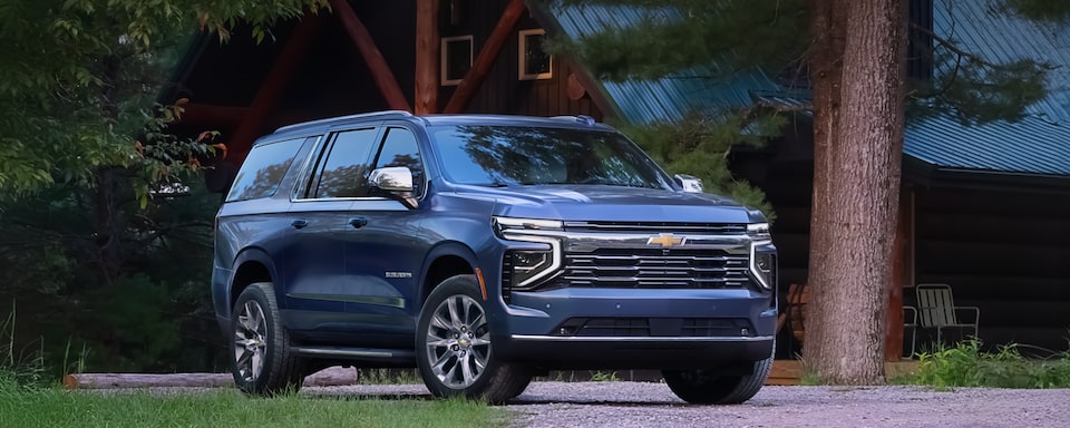 Front Three-Quarters View of the 2025 Chevrolet Suburban SUV Parked in Front of a Lake